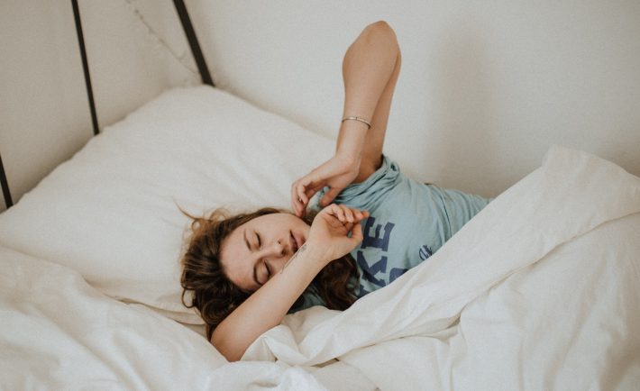 a woman struggling to get out of bed