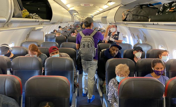 majority of people wearing masks on a flight