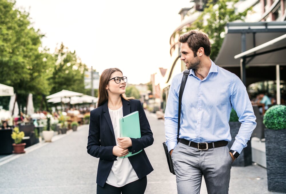 two coworkers walking and talking