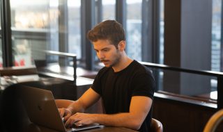 man typing on his laptop