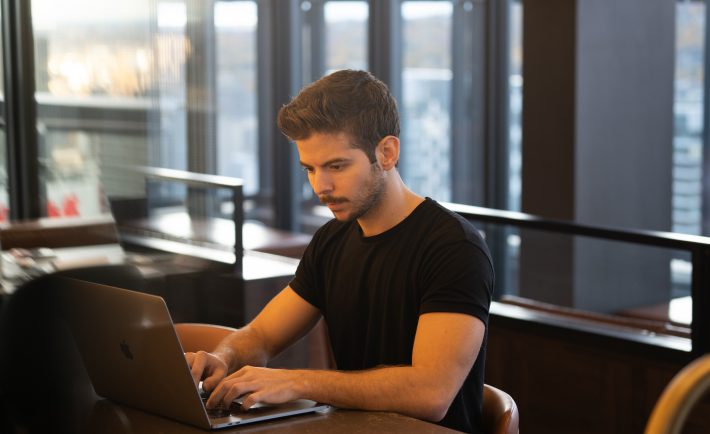 man typing on his laptop