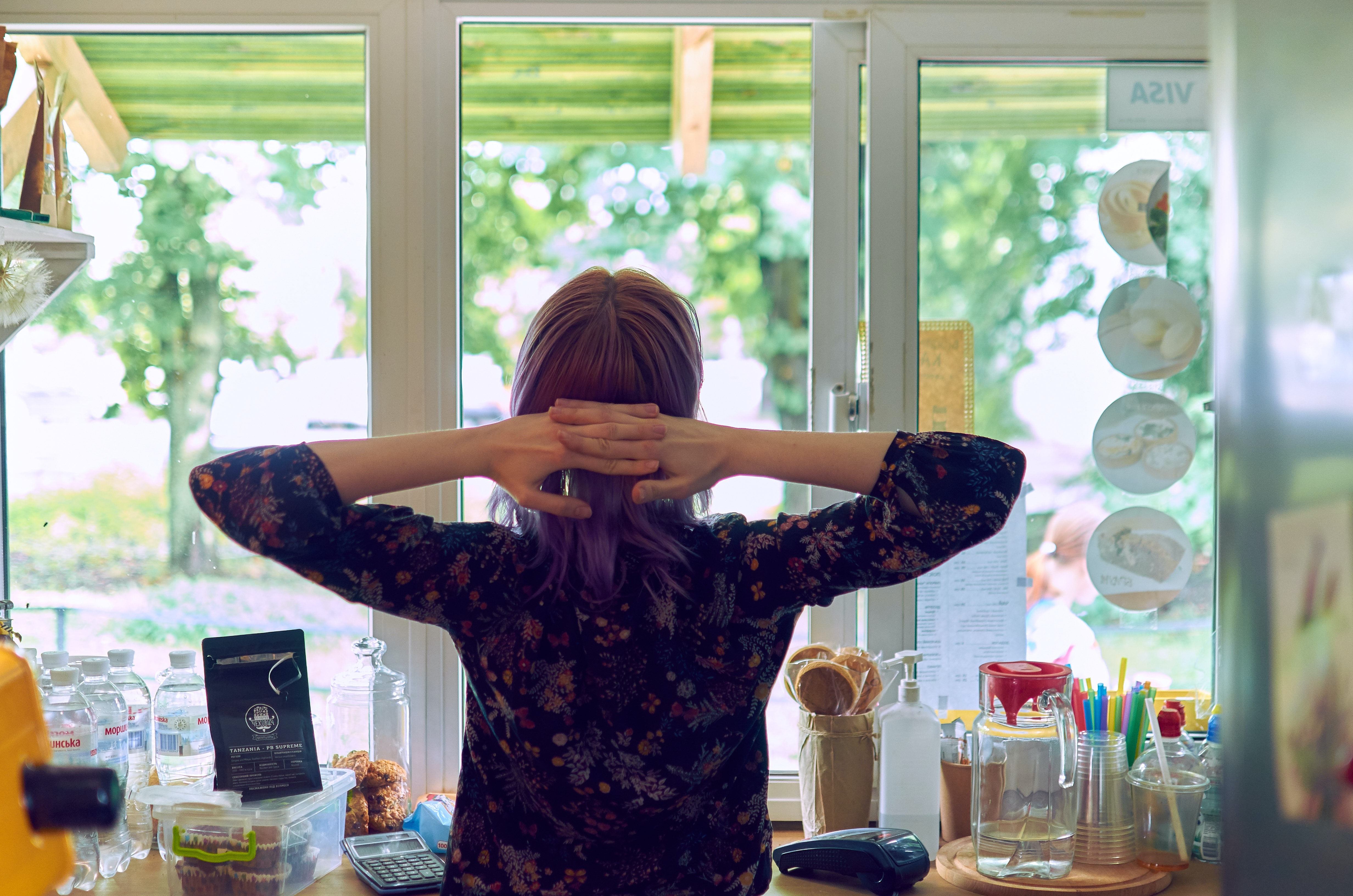 woman stretching while facing a glass window