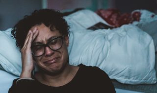 person crying beside the bed