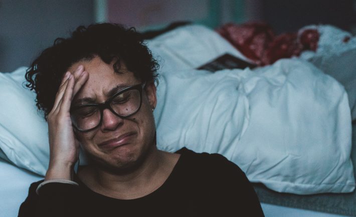 person crying beside the bed