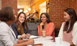 four women in a business meeting in a cafe