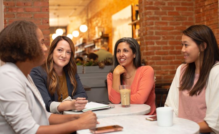 four women in a business meeting in a cafe