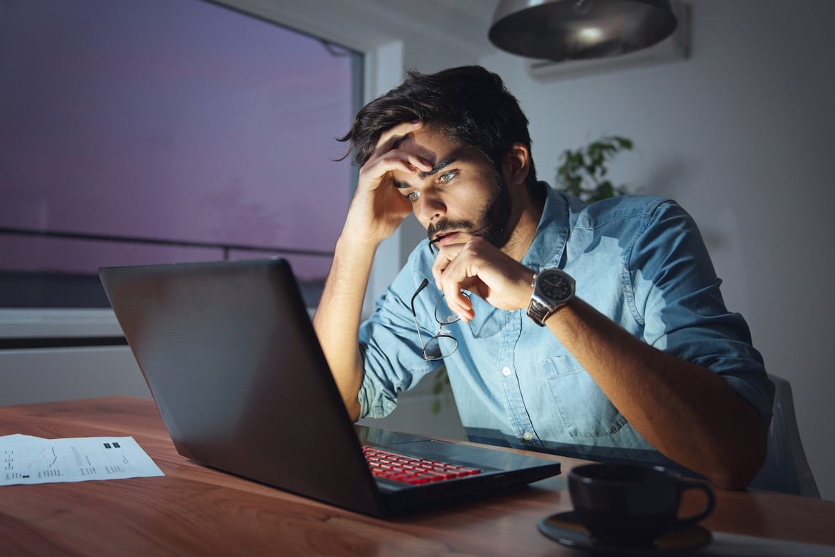 man stressed while working on his laptop