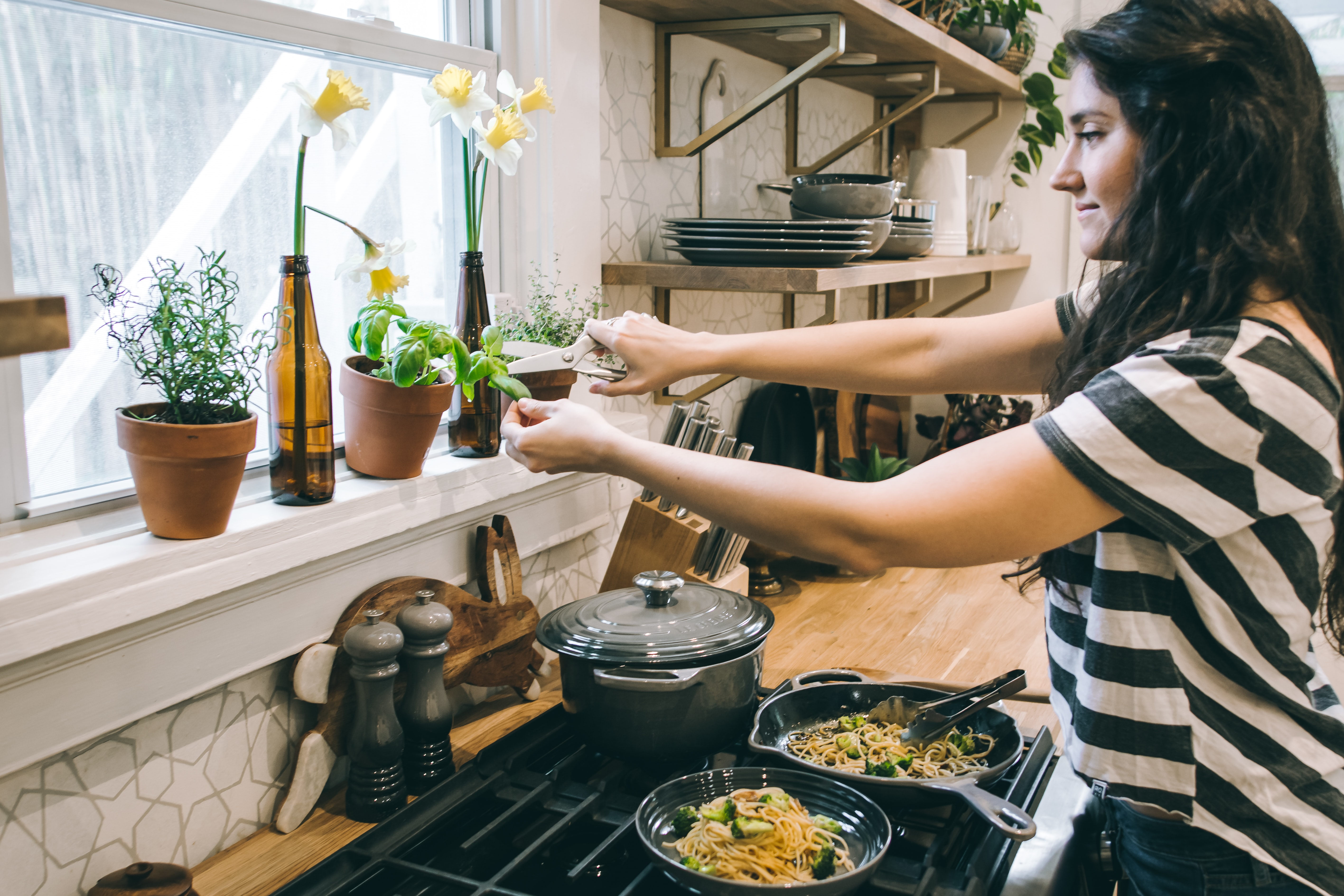 woman cutting fresh herbs for cooking