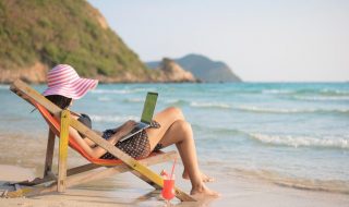 woman using laptop at the beach