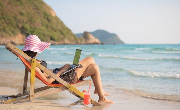 woman using laptop at the beach