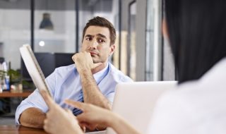 man raising eyebrows in a conversation with his coworker