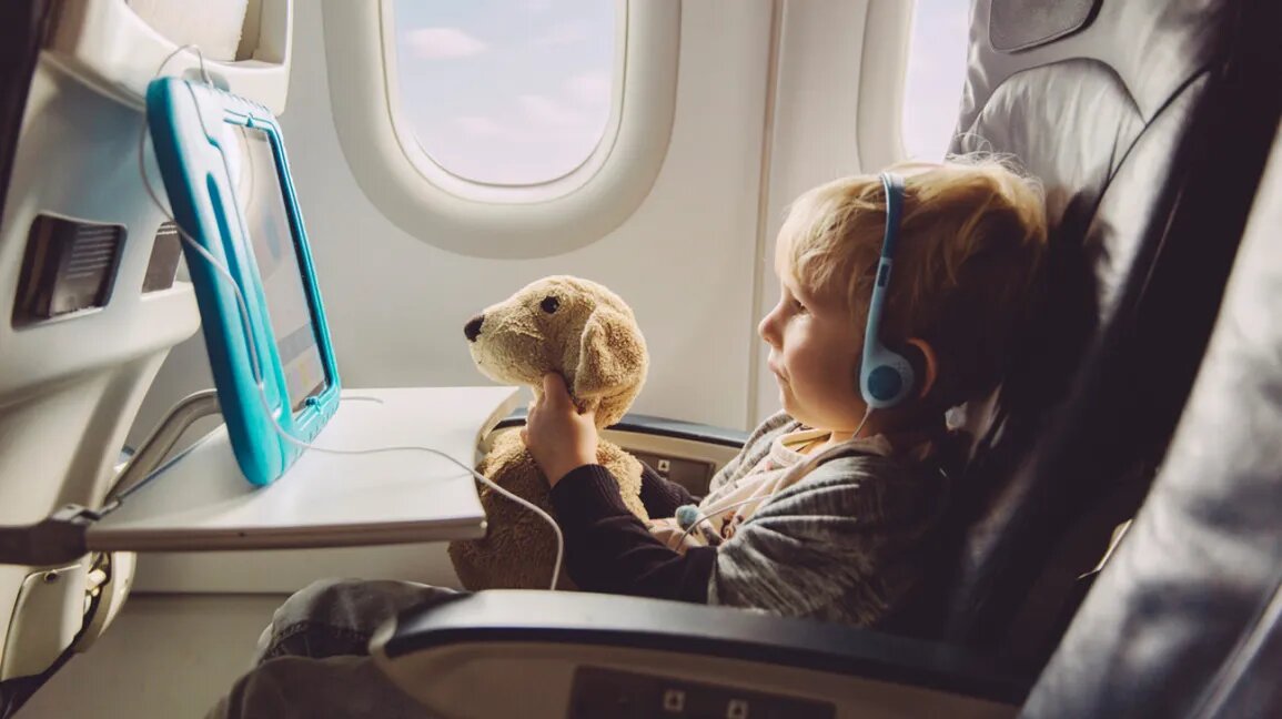 toddler with headphones holding a stuffed animal