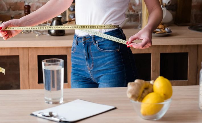 woman measuring her waist