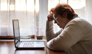 worried senior woman in front of her laptop