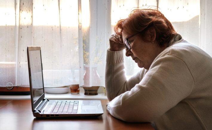 worried senior woman in front of her laptop