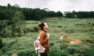 woman standing in the middle of the green fields