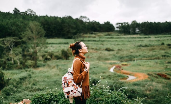 woman standing in the middle of the green fields