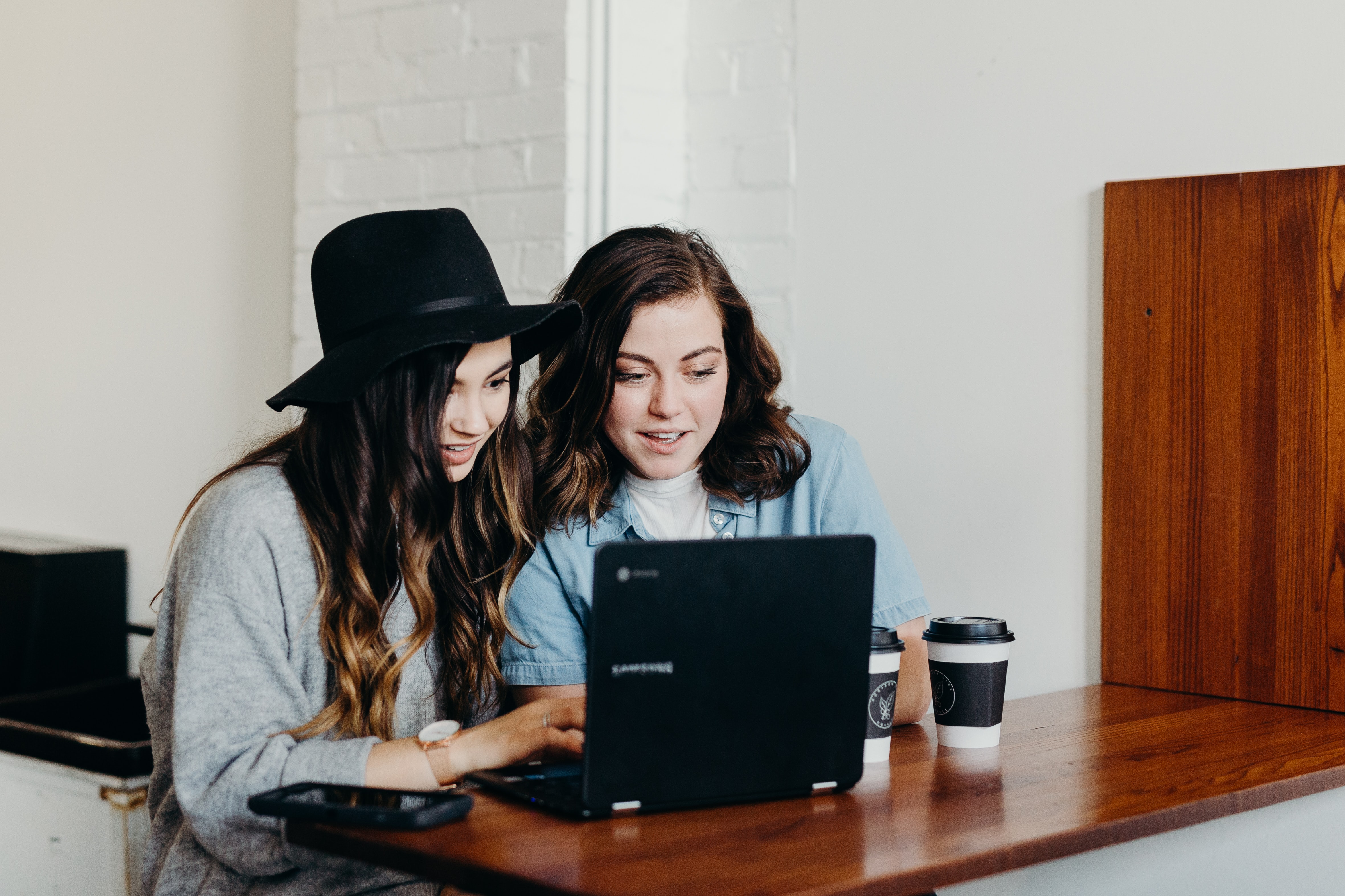 two ladies looking at their laptop