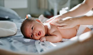 newborn baby lying on the bed