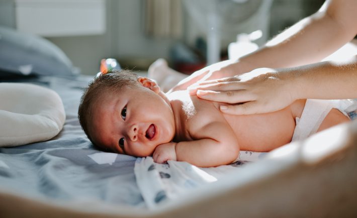 newborn baby lying on the bed