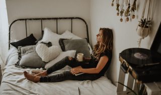 woman leaning against the wall in bed