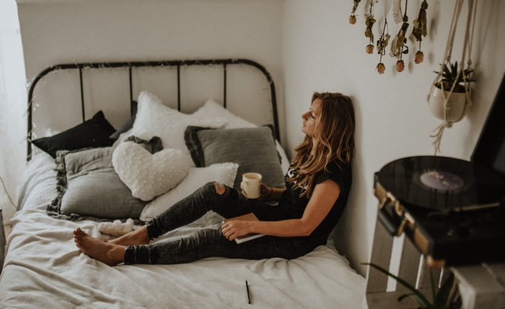 woman leaning against the wall in bed