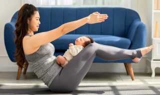 woman holding a yoga pose with baby sleeping on her thighs