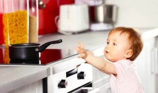baby reaching out to a pot in the kitchen