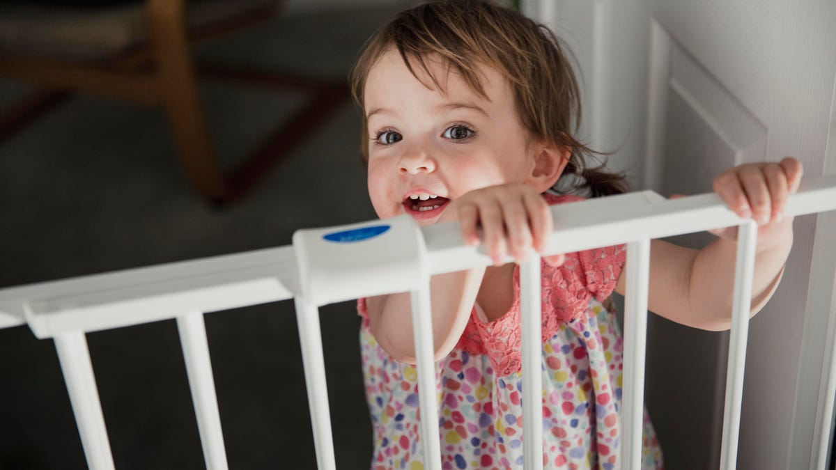 baby standing at a safety gate