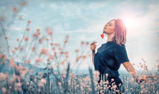 woman holding a red flower