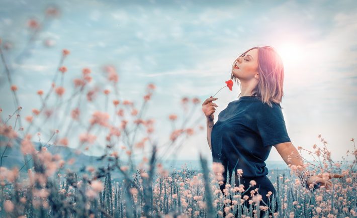 woman holding a red flower