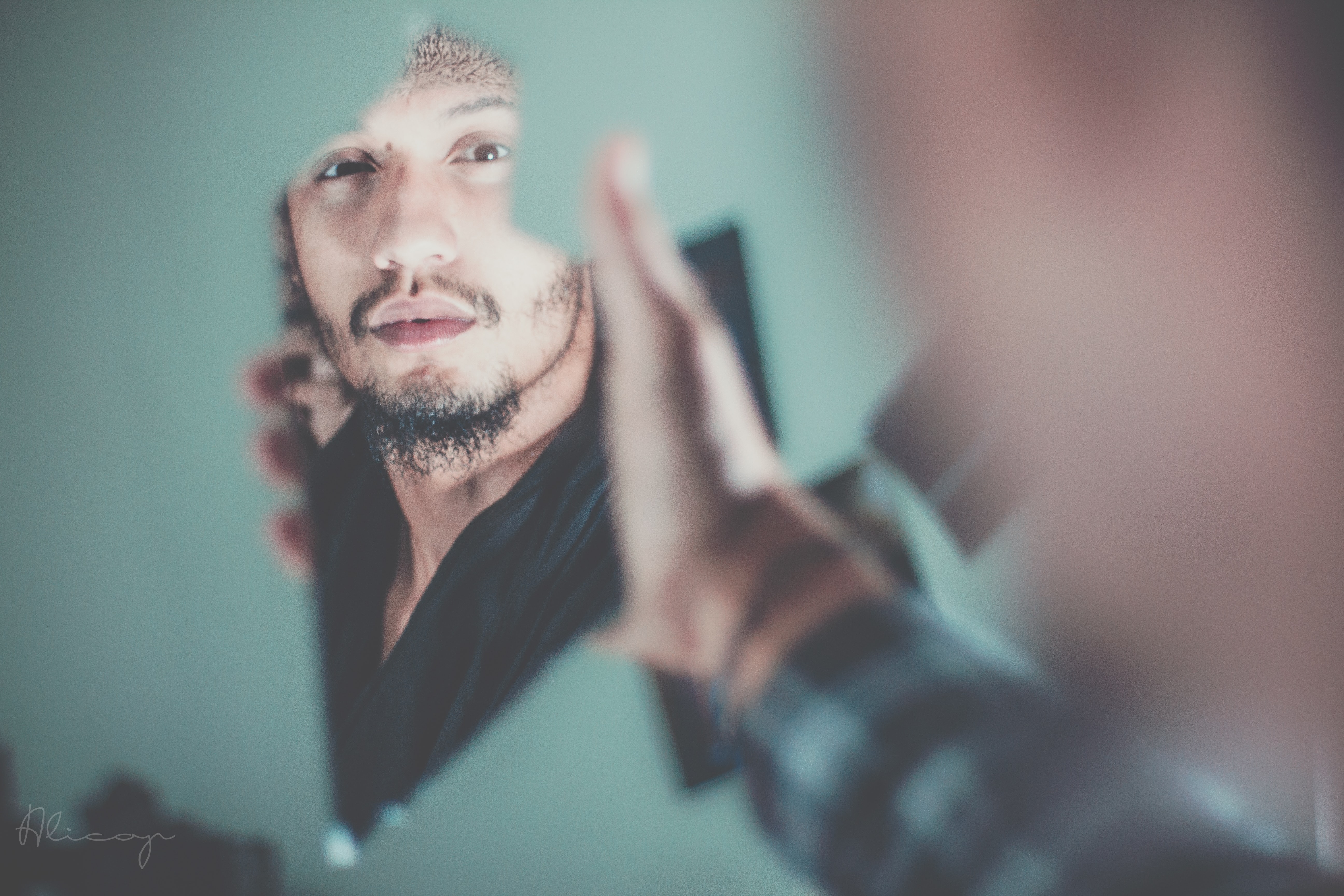 man looking into a broken piece of mirror