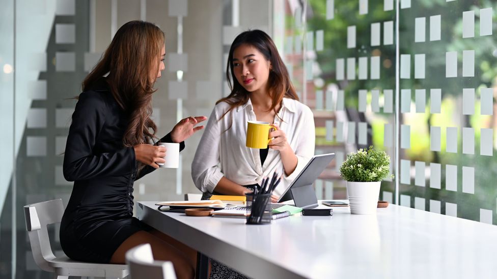 female colleagues discussing work over coffee