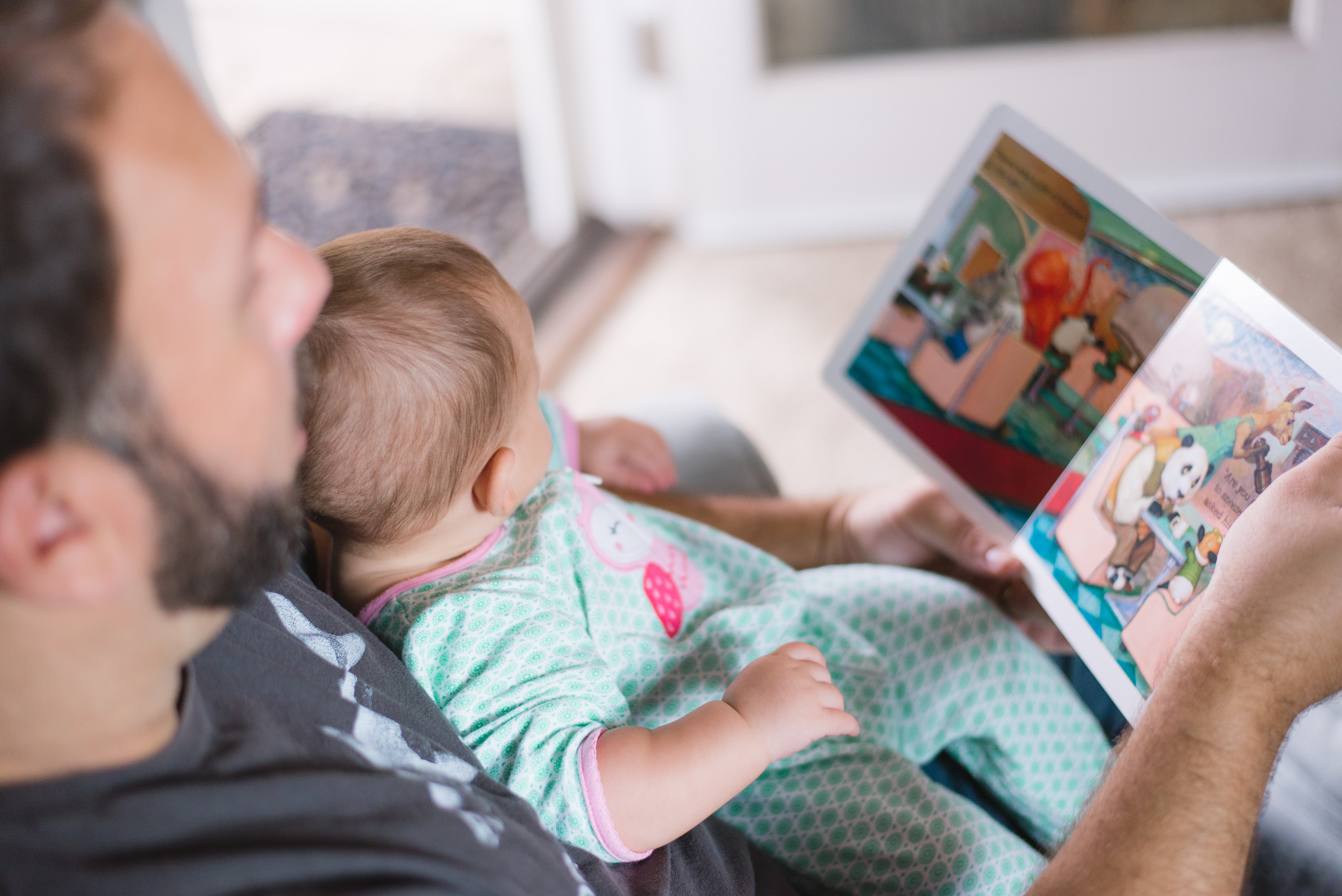 man reading a book to a baby