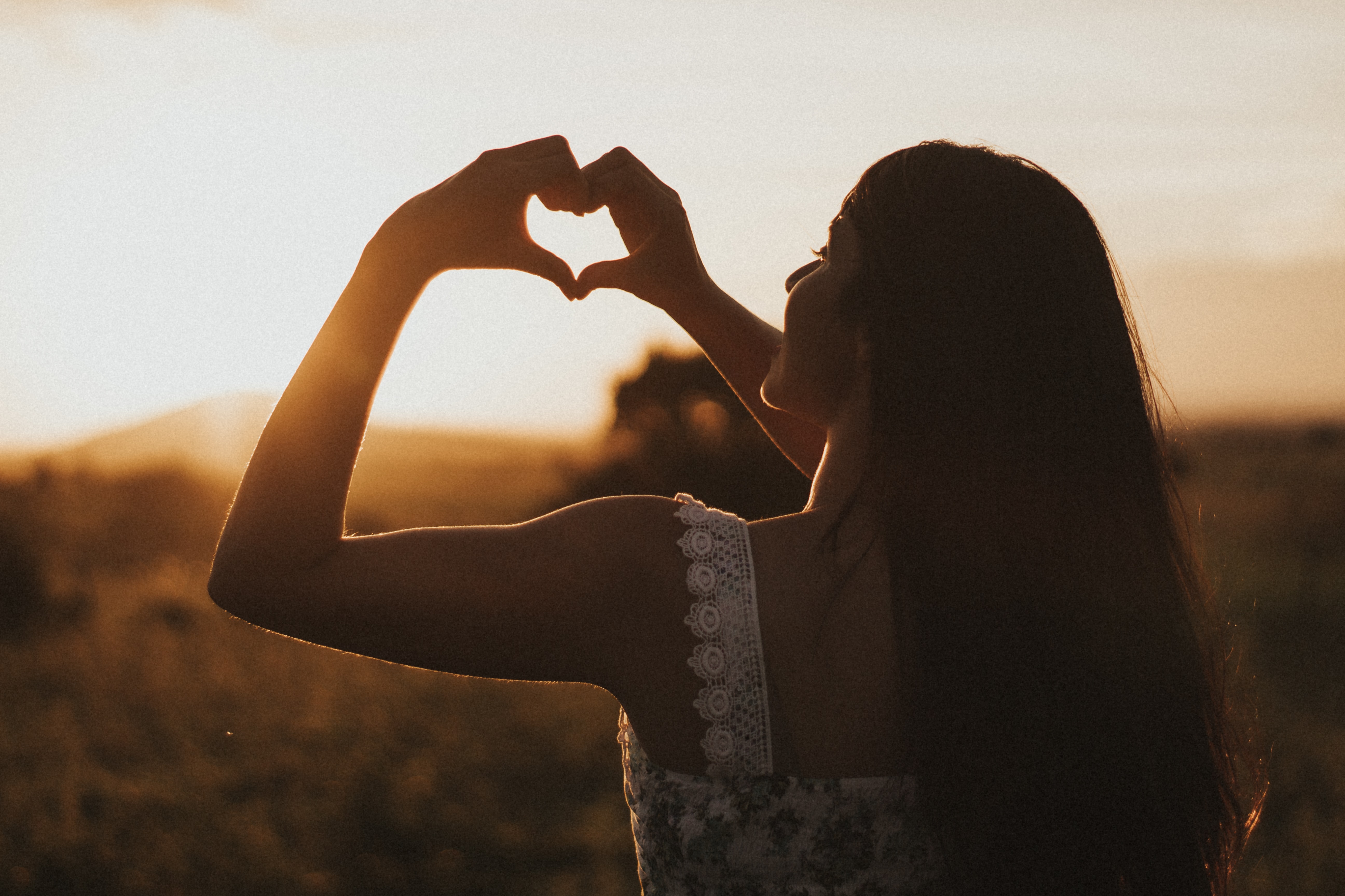 woman forming a heart with her hands