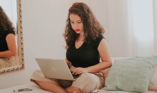woman working on her laptop in bed