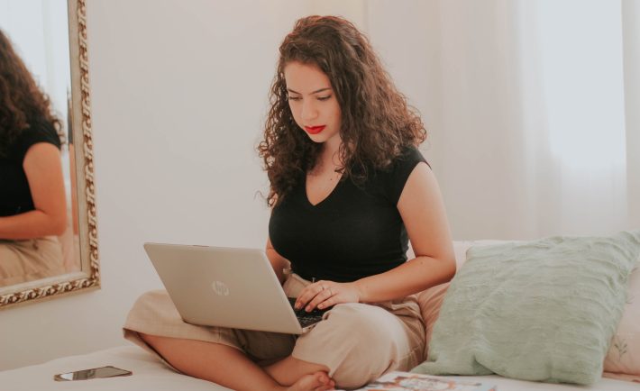 woman working on her laptop in bed