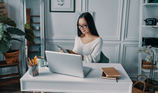 young lady looking at her tablet while working from home