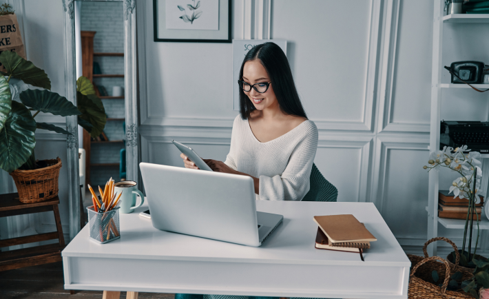 young lady looking at her tablet while working from home