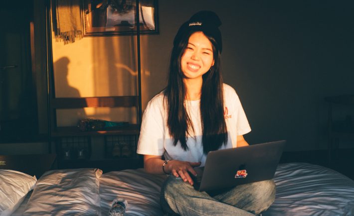 woman sitting on the bed with her laptop