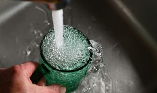 tap water overflowing in a cup