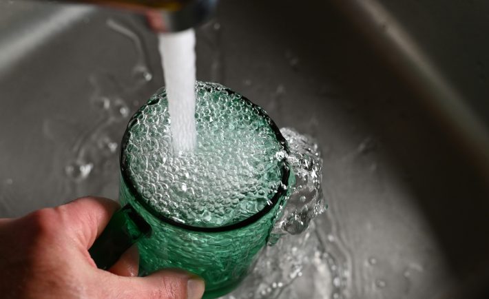 tap water overflowing in a cup