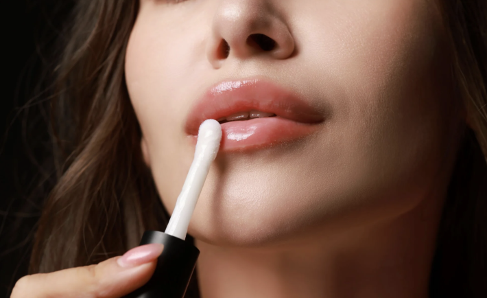 woman applying lip oil