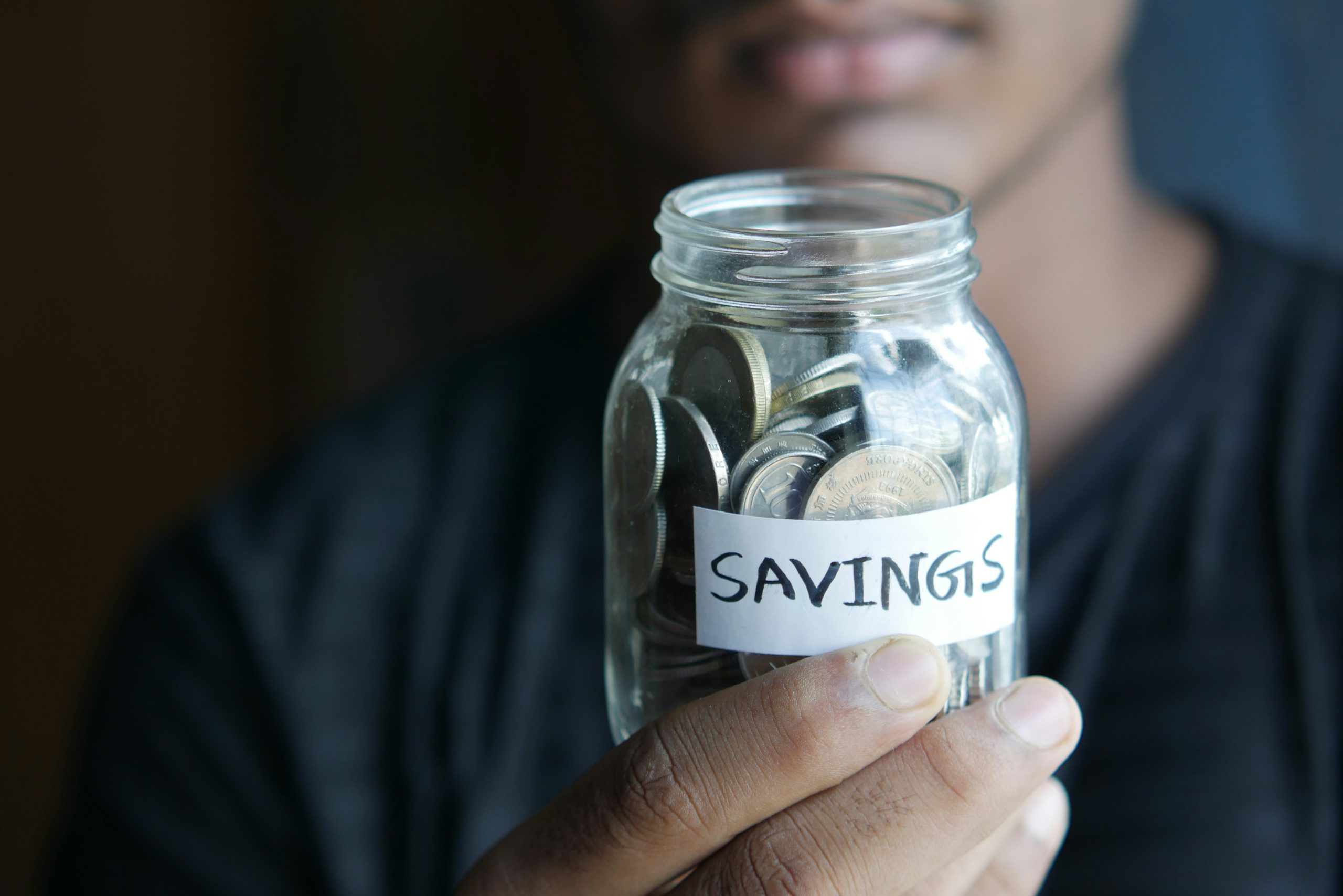 a man holding a savings jar