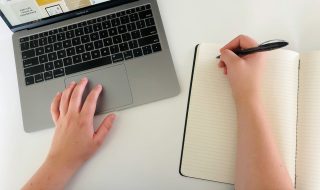 hands on a laptop and notebook
