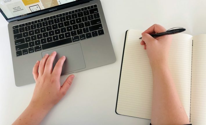 hands on a laptop and notebook