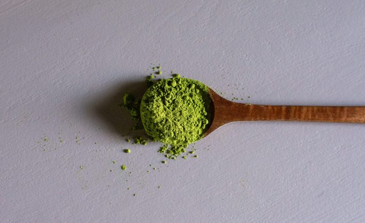 a wooden spoonful of matcha powder
