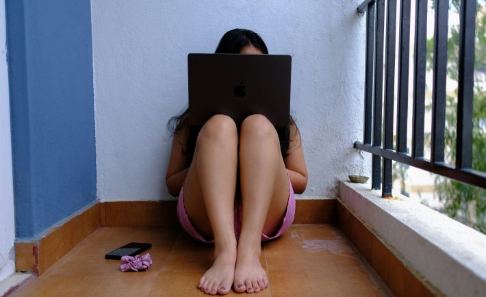 woman sitting on the floor using her laptop