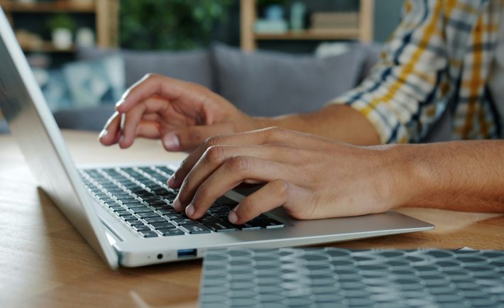 hands typing on a laptop
